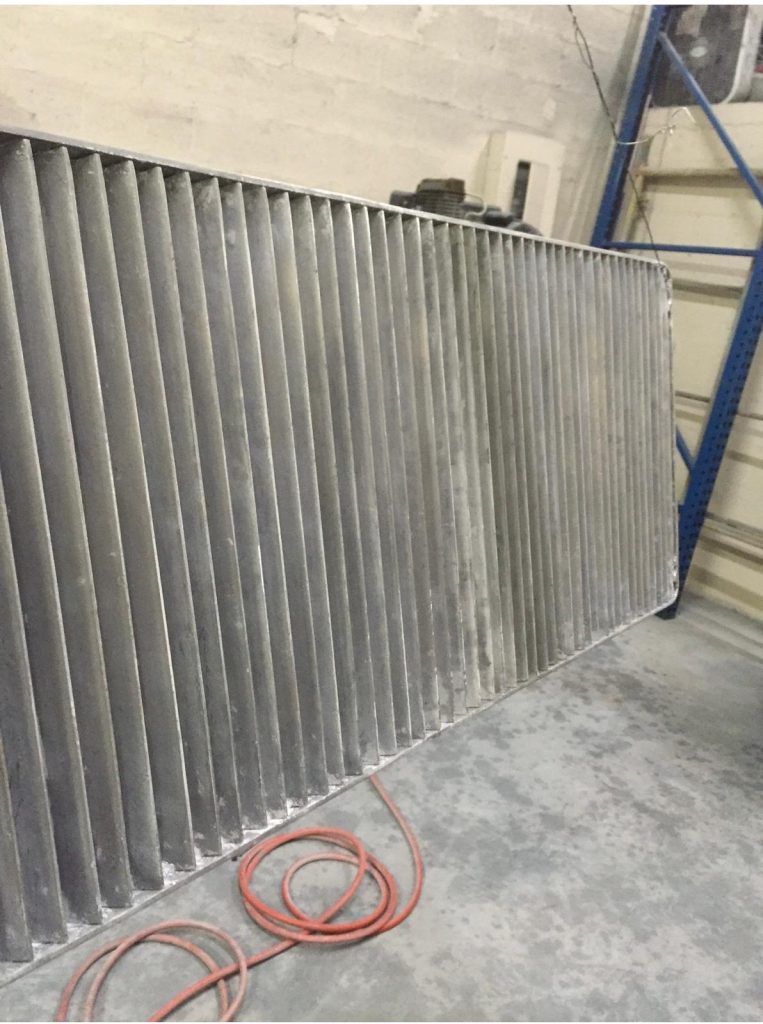 Aluminum louvered panel sandblasted to bare metal before priming