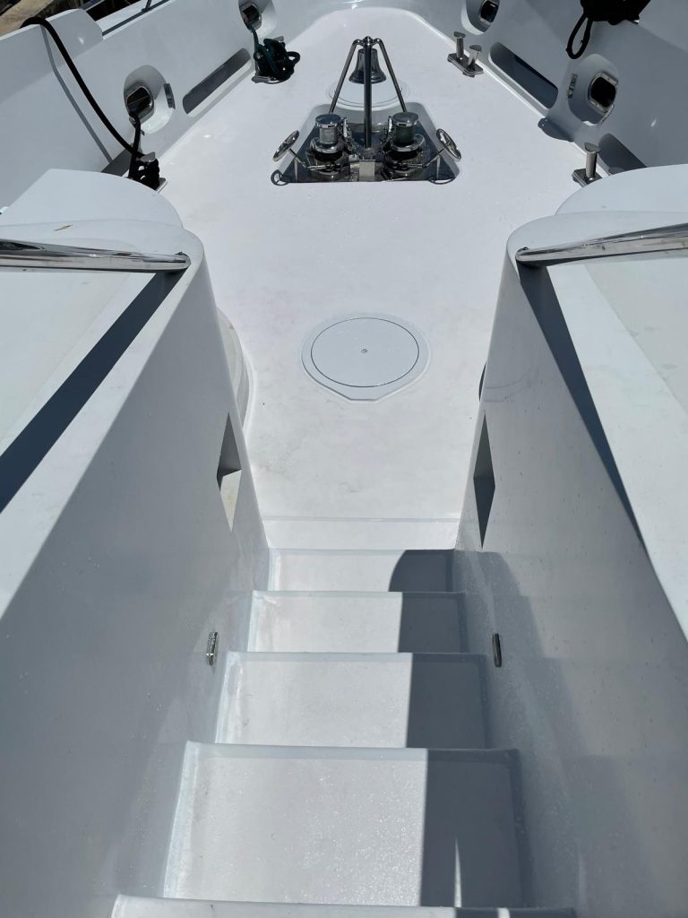 Yacht bow deck and steps freshly painted in white nonskid with anchor windlasses reinstalled